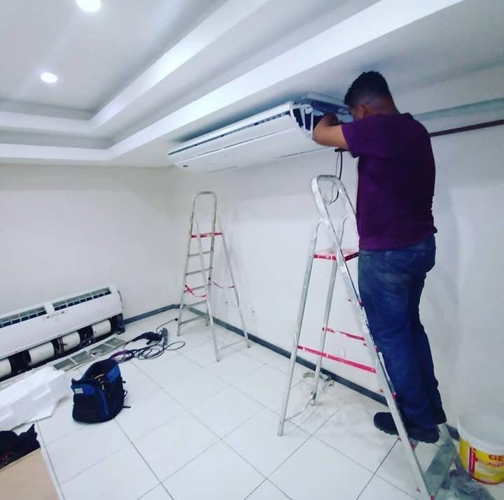 Técnico revisando a unidade interna de ar-condicionado