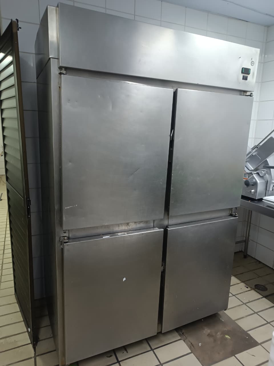 Refrigerador de inox com quatro portas em cozinha comercial